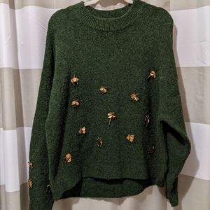 Green H & M sweater with gold flying insect accents. Size medium.